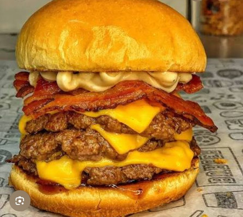 Super Neto. Pão brioche pestana, queijo prato, 3 hambúrguer Picanha 130gm, bacon, ovo, alface, tomate, molho verde, molho do chefe, molho de bacon e picles.